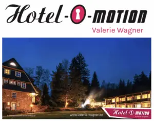 ALT-Text: Außenansicht des Hotels bei Dämmerung, umgeben von Bäumen, mit beleuchtetem Eingangsbereich und Fenstern.